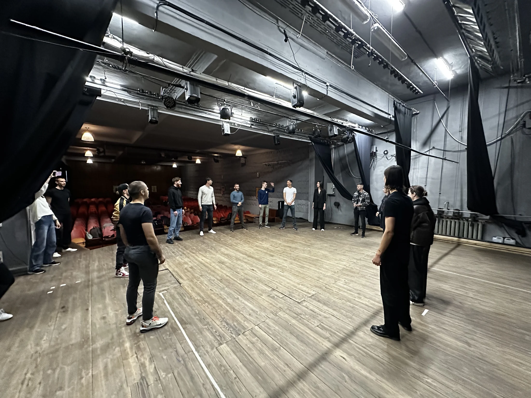 Grup de adulți în timpul unui exercițiu practic de actorie aplicată.